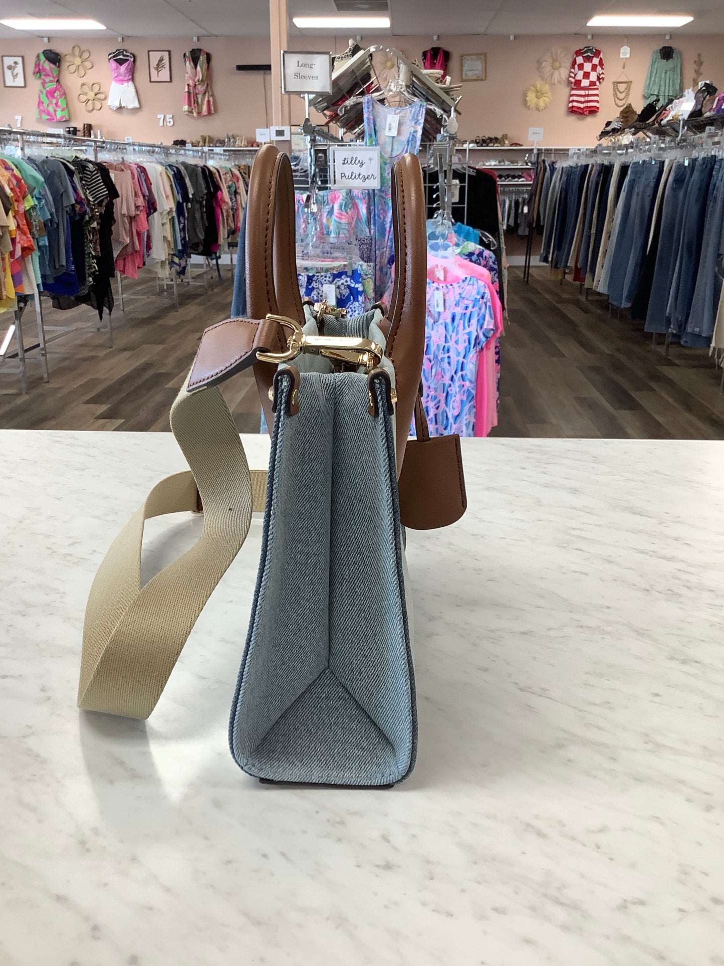 Michael Kors Mirella Small Denim Crossbody Bag in a blue washed denim material with brown leather trim