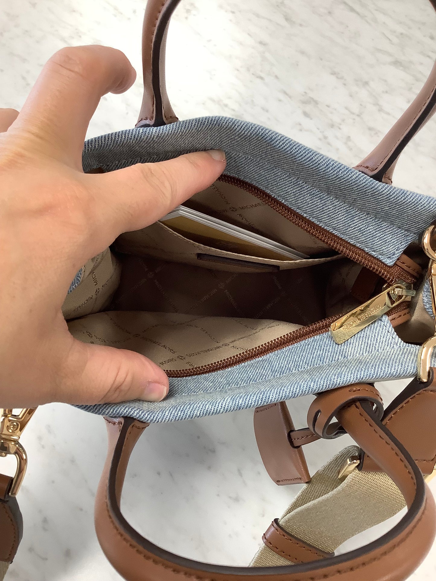 Michael Kors Mirella Small Denim Crossbody Bag in a blue washed denim material with brown leather trim