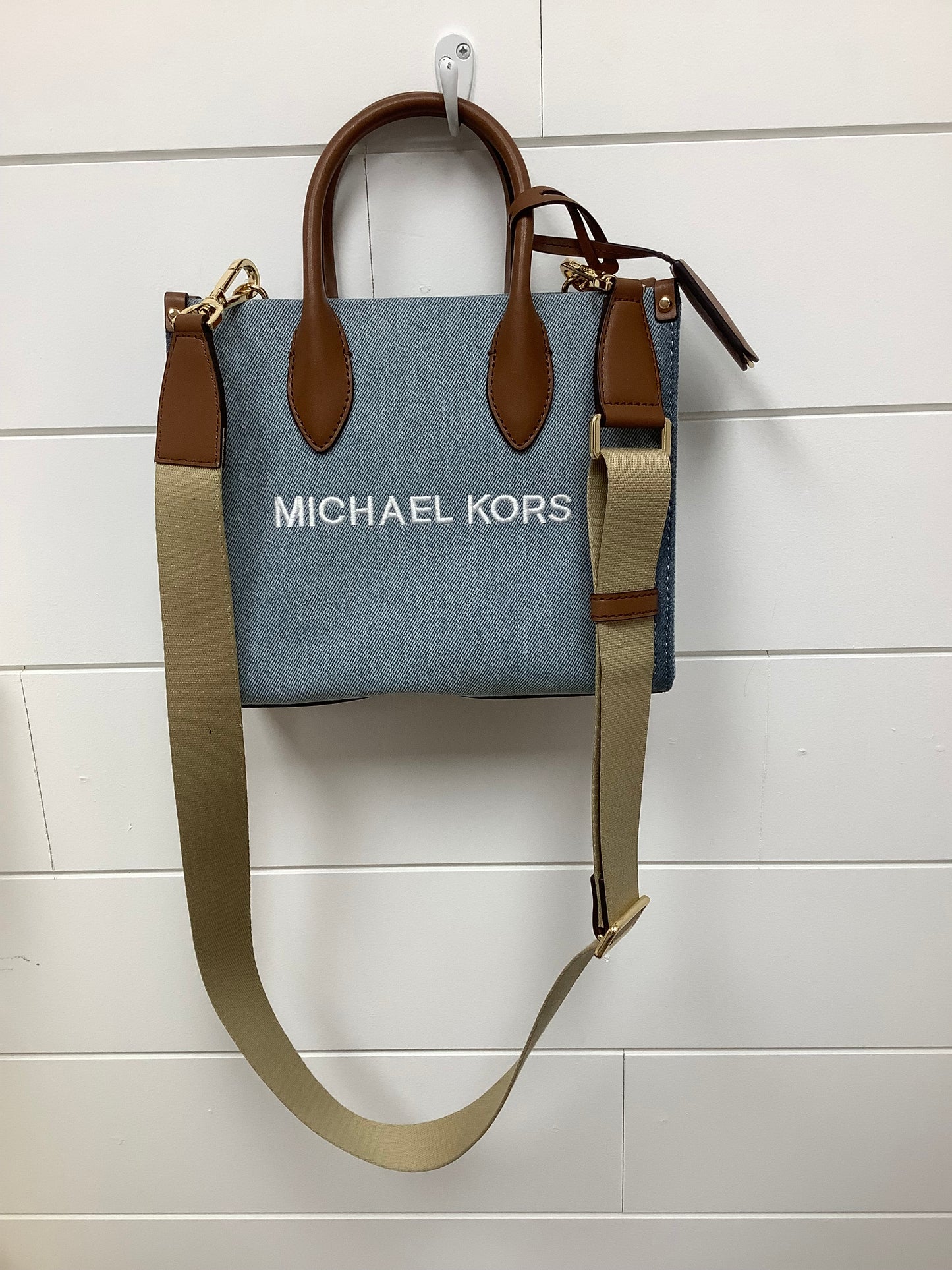 Michael Kors Mirella Small Denim Crossbody Bag in a blue washed denim material with brown leather trim